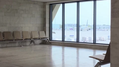 Empty terminal seating area overlooks a large window with airplanes outside.. Stock-Footage 345166197
