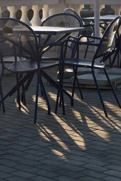 Empty terrace at sunset. Beautiful light and shadows on the pavement Stock Photos
