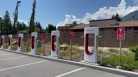 Empty Tesla electric Supercharger station at sunny day. Tesla electric vehicle Stock Footage 249145683