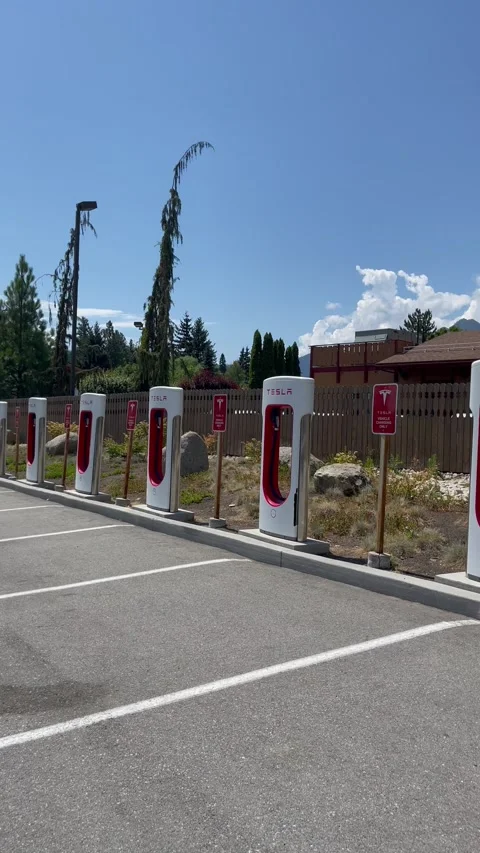 Empty Tesla electric Supercharger station at sunny day. Tesla electric vehicle Stock Footage 249145722