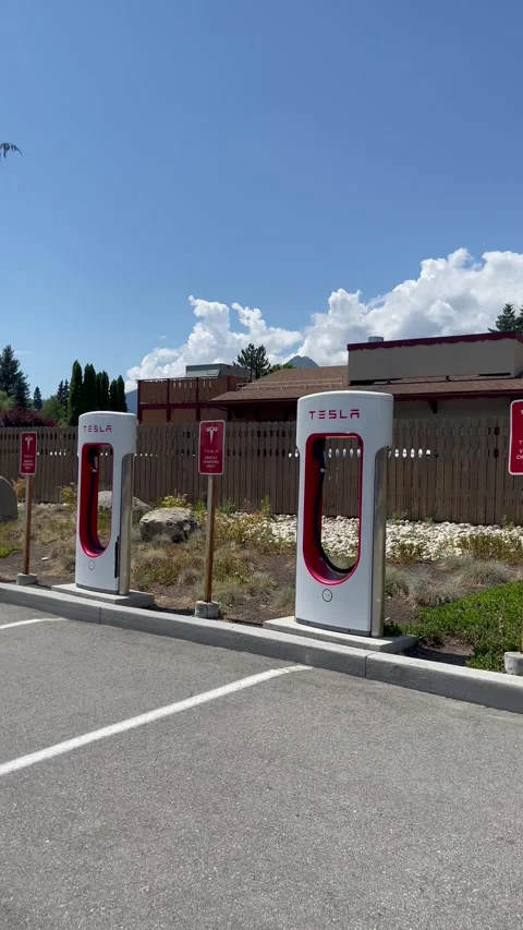 Empty Tesla electric Supercharger station at sunny day. Tesla electric vehicle Stock Footage 249430449