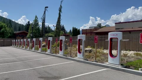 Empty Tesla electric Supercharger station at sunny day. Tesla electric vehicle Stock Footage 250563228