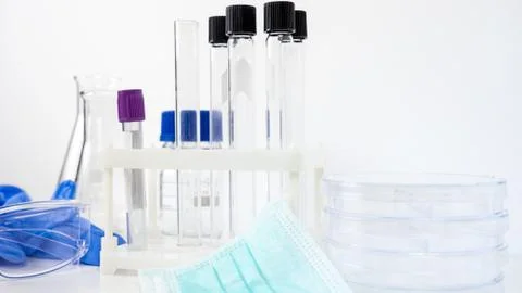 Empty Test Tubes and Flasks in Laboratory. Medical Mask and Gloves on Table Stock Photos