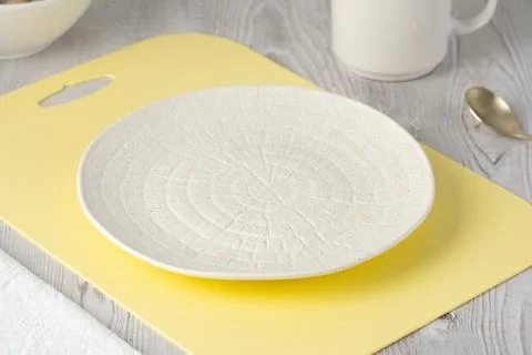 Empty textured light plate on yellow board 스톡 사진