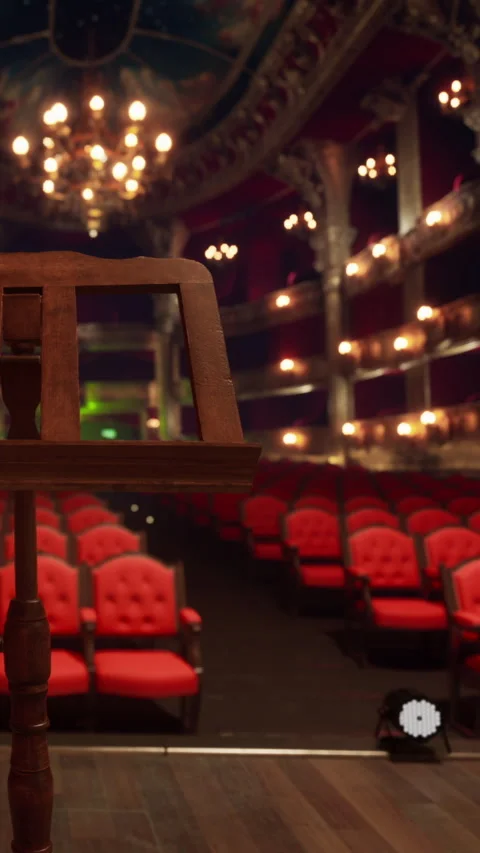 Empty theater with red seats and a wooden music stand in the foreground Stock Footage 339508208