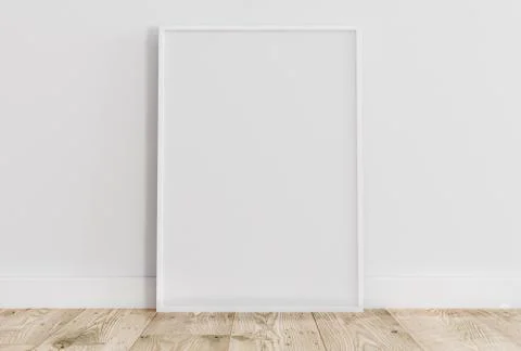 Empty thin white frame on light wooden floor with white wall behind it. Stock Photos