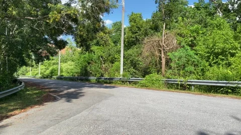 Empty three way junction panning shot on a sunny day tree and forrest. Crossroad Video stock 283171440