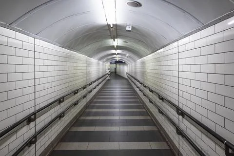 Empty tiled underground pedestrian tunnel Stockfoto's