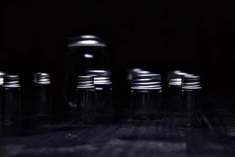 Empty tiny jars on a black surface Stock Photos