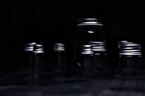 Empty tiny jars on a black surface Stock Photos