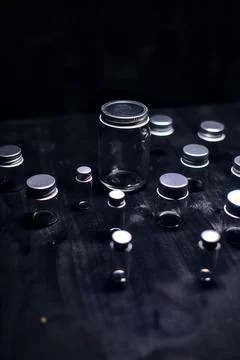 Empty tiny jars on a black surface Stock Photos