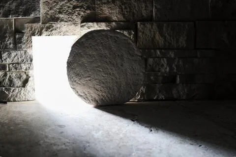 Empty tomb with stone rolled away and bright light Stock Photos