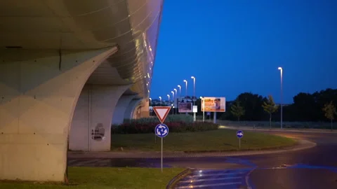 Empty traffic roundabout with big bridge at blue hour in the night Stock Footage 154900392