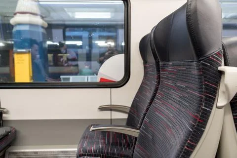 Empty train seats viewed through a window at Liverpool Street Station. Armr.. Foto stock