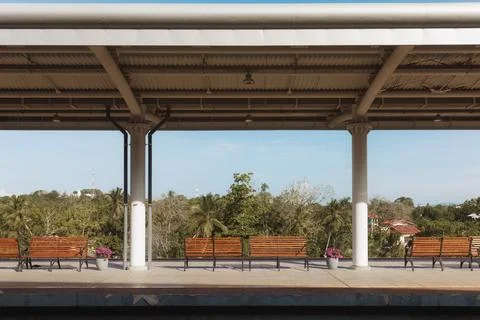 Empty Train Station Platform with Benches and Palm Trees Stock Photos