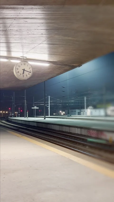 Empty train station platform at night with a clock Vídeos de archivo 346557088