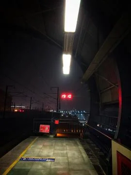 Empty Train Station Platform at Night with Digital Clock Display Stock Photos