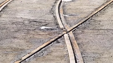 Empty tram crossing on an asphalt road, visible in perspective Stock Footage 340065330