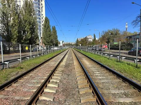 Empty tram tracks in the distant perspective of the city during the day Stock Photos