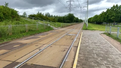 Empty tram tracks on wet platform with overhead wires Stock Footage 339723502