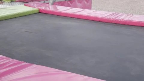 Empty Trampoline With Pink Padding in Outdoor Playground After Jumping Activity Stock Footage 337688607