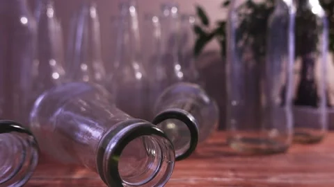 Empty Transparent Glass Bottles Rolling On The Table Close up Stock Footage 148402517