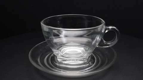 Empty transparent glass tea cup and saucer rotate shake move on black backg.. Stock Footage 263184765