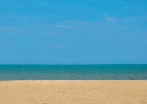 Empty Tropical Beach and Calm Blue Sea Under a Clear Sky Stock Photos