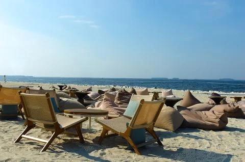 Empty tropical beach background with table chairs and pillows as relaxing f.. Stock Photos
