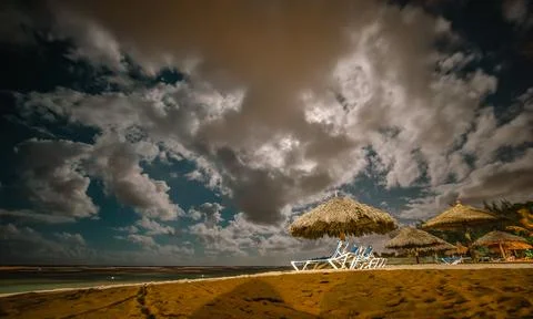 Empty tropical beach with beach chairs at night under full moon shine Stock Photos