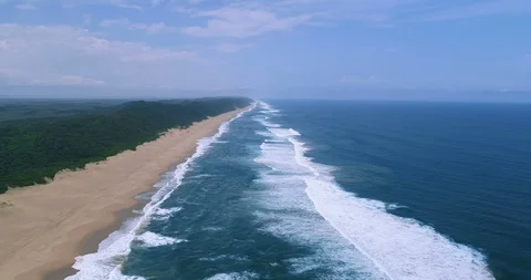Empty tropical beach viewed from drone lowering itself to sea level aerial 4K Stock Footage 87573860