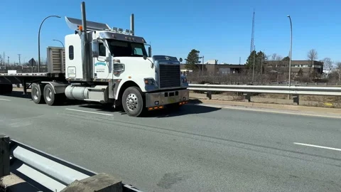 An empty truck with a semi-trailer pulls into an intersection at the exit city. Video stock 238535246