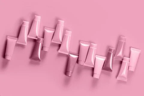 Empty tubes for the design of cosmetics on red background. Stock Photos