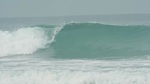 Empty turquoise sea wave forms a barrel and crashes on a misty day Видео 344572399