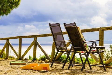 Empty two camp chairs on sea shore Stock Photos