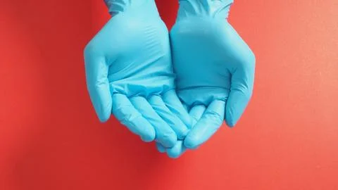 Empty two hand with gloves doing sign for help on red background. Stock Photos