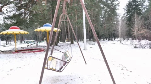 Empty two-seater swings can be found in forest playground for children in winter Stock Footage 277929903