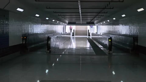 Empty underground passage with two travelators with light at end of it Stock Footage 222436189
