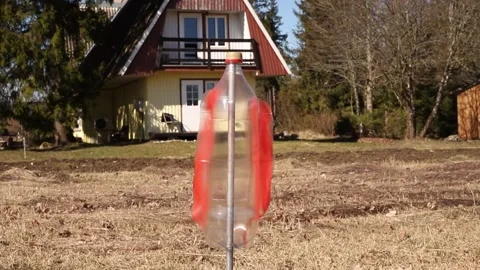 An empty upside-down plastic bottle spins in the garden. Stock-Footage 312546799