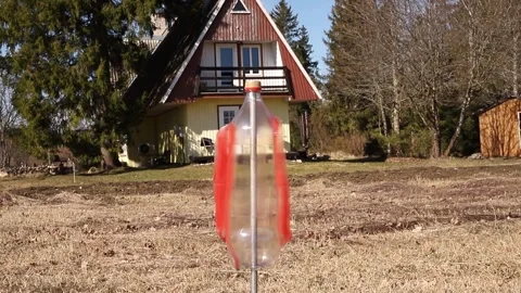 An empty upside-down plastic bottle spins in the garden. Stock-Footage 312546812