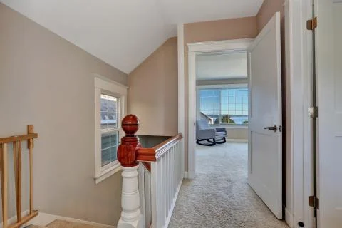 Empty upstairs hallway interior with light pink walls. Also vaulted ceiling a Stock Photos
