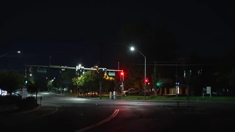 Empty urban intersection with traffic lights and streetlights late at night Stock Footage 346917721