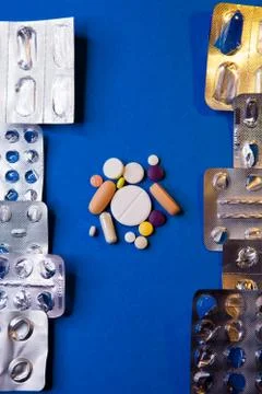 Empty used blister package and different pills on blue background Stock Photos