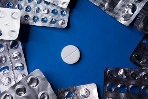 Empty used blister package and pill on blue background Stock Photos