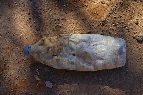 Empty used dirty bottles on the ground. Stock Photos