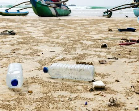 Empty used plastic bottles and other waste thrown out at sea beach. Stock Photos
