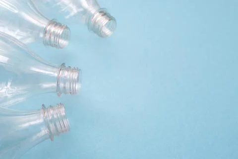 Empty used plastic bottles on blue background with place for text. Copy space Stock Photos