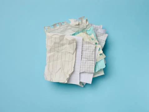 Empty various blank crumpled pieces of sheets torn from a notebook on a blu.. Stock Photos