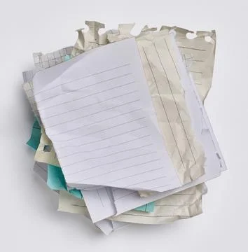 Empty various blank crumpled pieces of sheets torn from a notebook on a whi.. Stock Photos