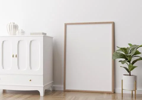 Empty vertical picture frame standing on parquet floor in modern living room. Stock Photos